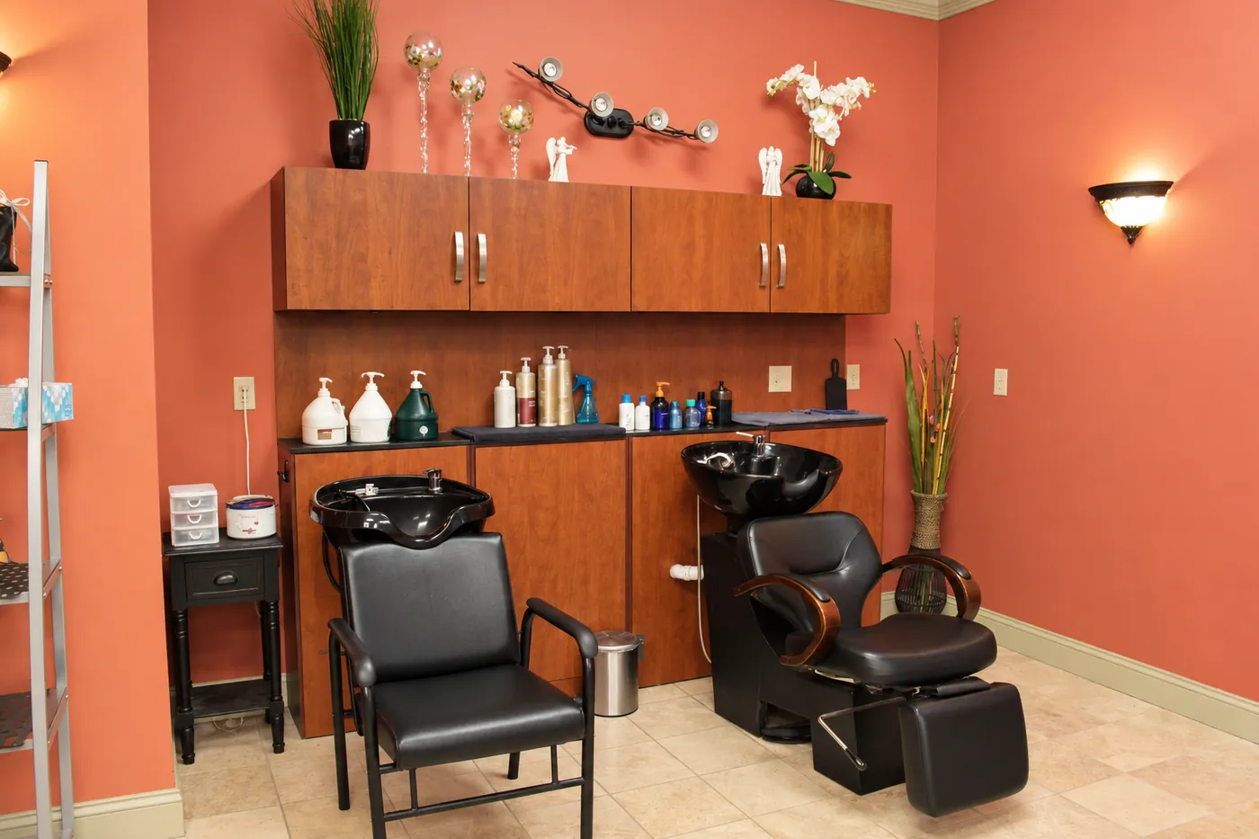Nu Look Salon shampoo area with two black shampoo chairs and wood cabinets